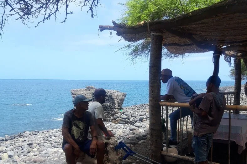 plage-tarrafal-monte-trigo des hommes sont posés au bord de la plage de Tarrafal de Monte Trigo