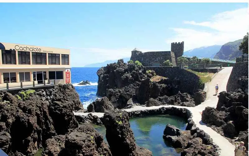 Un établissement prés du littoral de madere, la mer dérriere, et une picsine naturelle devant