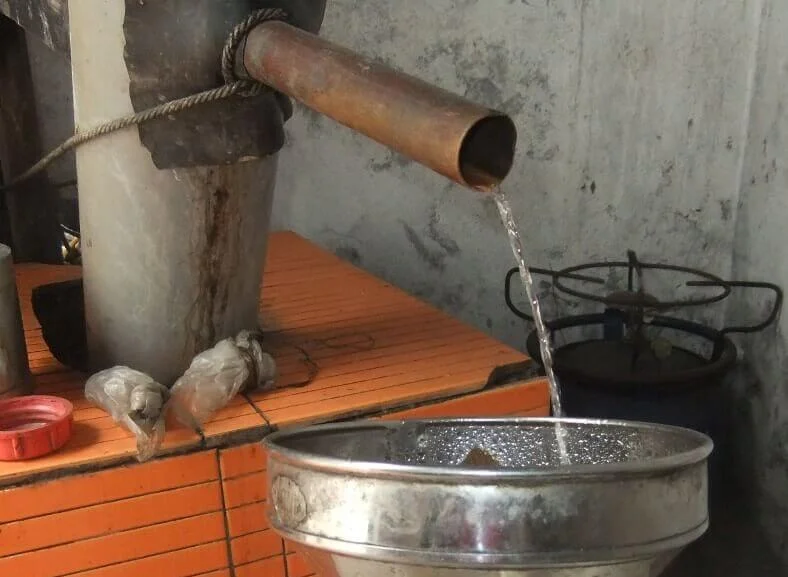  rhum santo antao, le rhum coule d'un tuyau en cuivre dans un jerricane