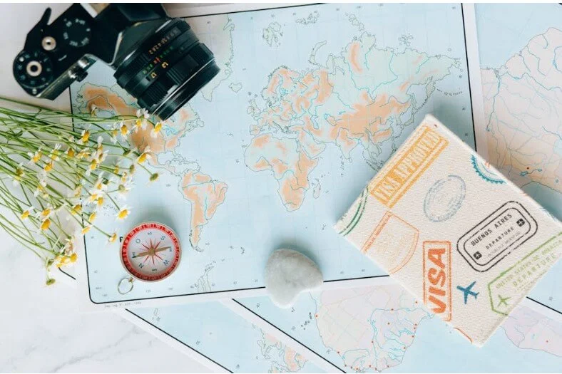 visa cap vert, un visa pausé sur une table avec des accessoires de voyage