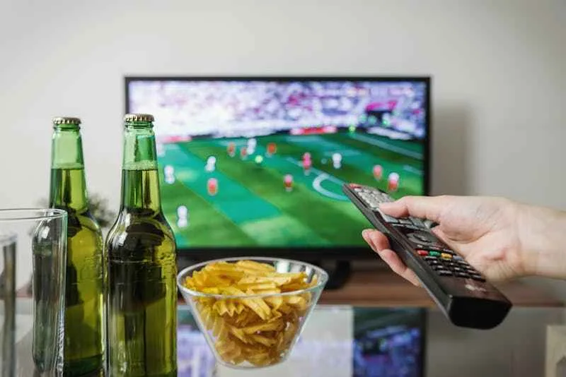chaines television cap vert, une personne zappe sur la télé en marche, du foot au programme