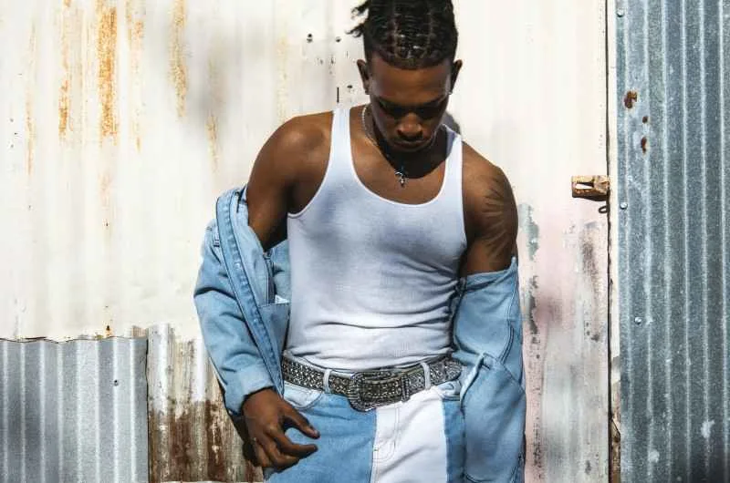 tendances et influences cap vert, un homme noir pose en jean bicolore et chemise ouverte